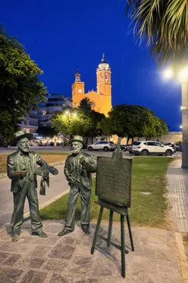a statue of two men standing next to a sign at Modern Duplex in Sitges with Private Parking, Sea Views & Terrace in Sitges