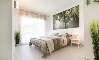 a bedroom with a bed and a large window at Modern Duplex in Sitges with Private Parking, Sea Views & Terrace in Sitges