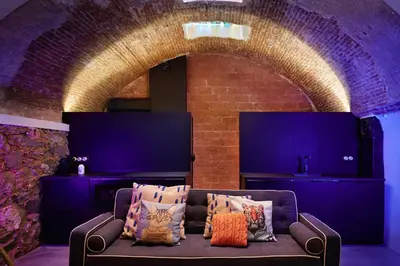 a couch in a room with a brick wall at Dormsy Pension Boutique in Arenys de Mar