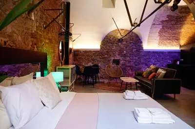 a bedroom with a bed and a living room at Dormsy Pension Boutique in Arenys de Mar