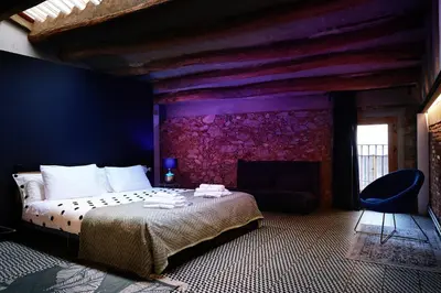 a bedroom with a bed and a purple wall at Dormsy Pension Boutique in Arenys de Mar