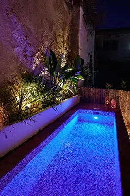 a swimming pool with purple lights in a backyard at Dormsy Pension Boutique in Arenys de Mar