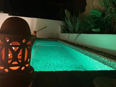 a swimming pool in a backyard at night at Dormsy Pension Boutique in Arenys de Mar