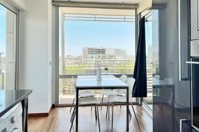 a dining room with a table and chairs and a large window at Ral48 in Sant Adria de Besos