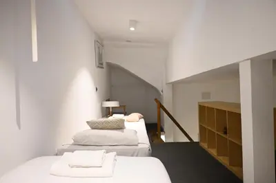 a bedroom with three beds and a stairway at Homenfun Barcelona Vallcarca in Barcelona