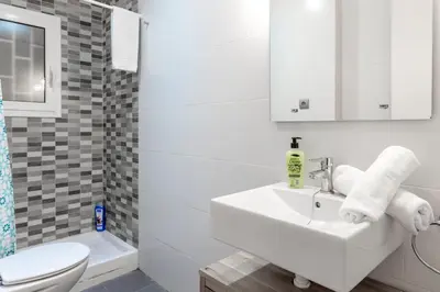 a white bathroom with a sink and a toilet at Autèntic Arc de Triomf Apartment in Barcelona