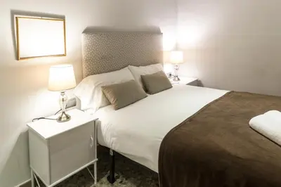 a bedroom with a large white bed with two lamps at Autèntic Arc de Triomf Apartment in Barcelona