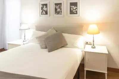 a bedroom with a white bed with two lamps at Autèntic Arc de Triomf Apartment in Barcelona