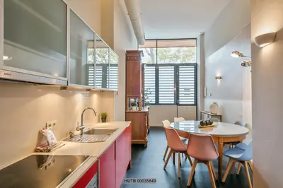 a kitchen with a sink and a table with chairs at Alcam Les Corts in Barcelona