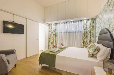 a bedroom with a large bed and a chair at Alcam Les Corts in Barcelona