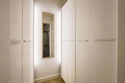 a hallway with white cabinets and a mirror at Alcam Les Corts in Barcelona