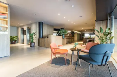 a lobby with chairs and a table in a building at Hotel Terrassa Confort in Terrassa