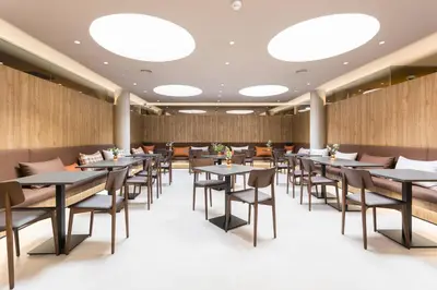 a dining room with tables and chairs and lights at Hotel Terrassa Confort in Terrassa