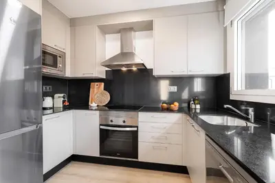 a kitchen with white cabinets and a stove top oven at Calella Apartments by Olala Homes in Calella