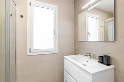 a white bathroom with a sink and a mirror at Calella Apartments by Olala Homes in Calella
