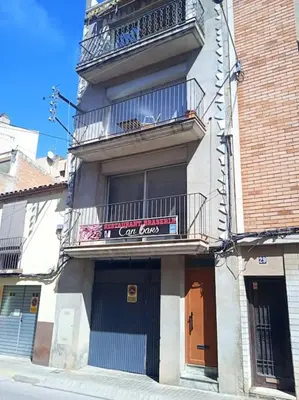 a building with a balcony and a cafe boss sign on it at piso con vistas a la montaña in Monistrol
