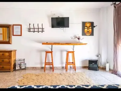 a room with a table and a tv on a wall at piso con vistas a la montaña in Monistrol