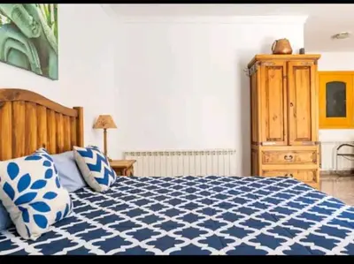 a bedroom with a blue and white bed and a dresser at piso con vistas a la montaña in Monistrol