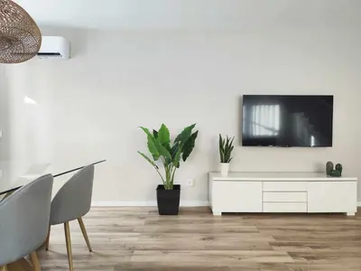 a living room with a tv on a white wall at Mazi Apartments Cuba in Mataró