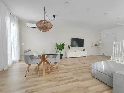 a dining room with a table and chairs and a couch at Mazi Apartments Cuba in Mataró