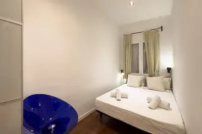 a bedroom with a bed and a blue chair at Sagrada Familia Bliss in Barcelona