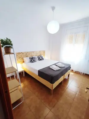 a bedroom with a bed and a ladder and a chair at Amplio apartamento con terraza in Hospitalet de Llobregat