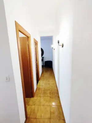 a hallway with two doors and a tile floor at Amplio apartamento con terraza in Hospitalet de Llobregat