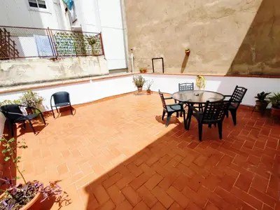 a patio with a table and chairs on a brick floor at Amplio apartamento con terraza in Hospitalet de Llobregat