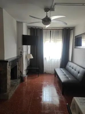 a living room with a couch and a fireplace at Apartamentos Can Bruguera 4 in Mataró