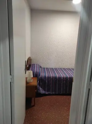 a small room with a bed and a table at Apartamentos Can Bruguera 4 in Mataró