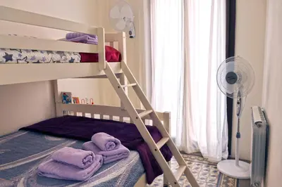 a bunk bed with towels on the bottom bunk at La LLar de la Kim, Bonita casa a 150m del mar y 40km de Barcelona in Arenys de Mar