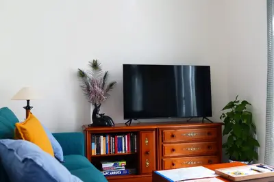 a living room with a television on a wooden entertainment center at La LLar de la Kim, Bonita casa a 150m del mar y 40km de Barcelona in Arenys de Mar
