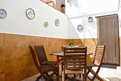 a table and chairs with plates on the wall at La LLar de la Kim, Bonita casa a 150m del mar y 40km de Barcelona in Arenys de Mar