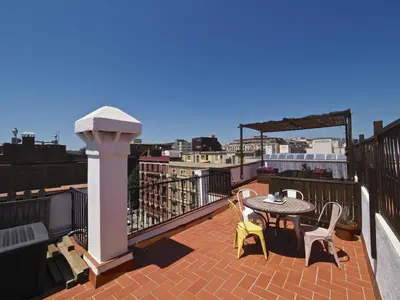 a patio with a table and chairs on a balcony at Sunny Rooftop Apartment in Barcelona