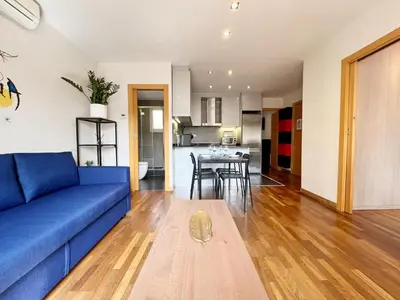 a living room with a blue couch and a table at Teatro Miro Apartment in Barcelona