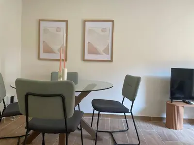 a dining room with a table and chairs and a television at Superflat near beach 15' center in Sant Adria de Besos