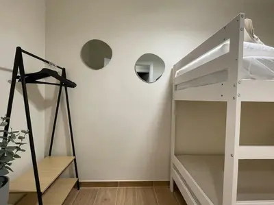a white bedroom with a bunk bed and a ladder at Superflat near beach 15' center in Sant Adria de Besos