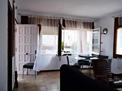 a living room with a table and a window at AFRODITA Casa con dos apartamentos independientes in Pineda de Mar