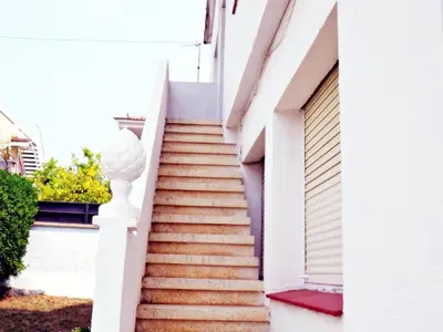a stairway leading up to a white building at AFRODITA Casa con dos apartamentos independientes in Pineda de Mar