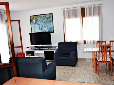 a living room with two chairs and a flat screen tv at AFRODITA Casa con dos apartamentos independientes in Pineda de Mar
