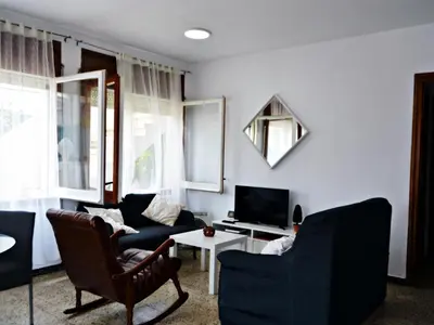 a living room with two chairs and a tv at AFRODITA Casa con dos apartamentos independientes in Pineda de Mar
