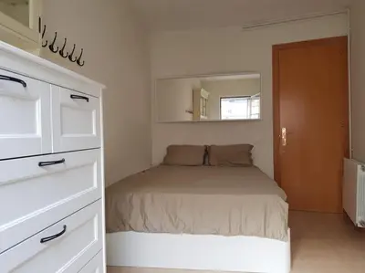 a small bedroom with a bed and a mirror at SITGES WELCOM HOME a summer flat in the heart of the village Sitges in Sitges