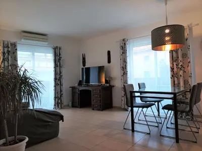 a living room with a table and chairs and a television at SITGES WELCOM HOME a summer flat in the heart of the village Sitges in Sitges