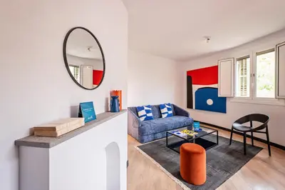 a living room with a blue couch and a mirror at Sweett - Casa Miro in Barcelona