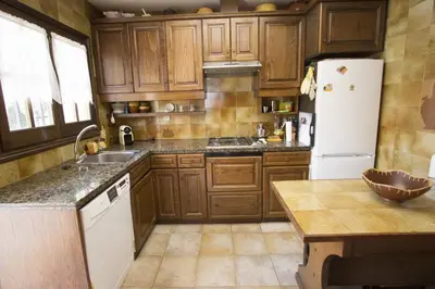 a kitchen with wooden cabinets and a white refrigerator at Catalunya Casas Private paradise - hop, skipjump to Barcelona! in Cervelló