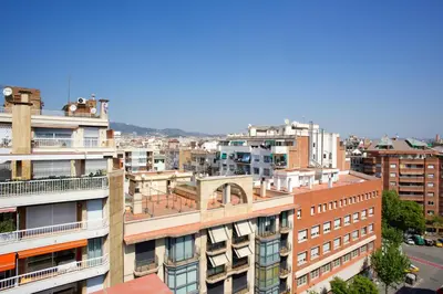 a kitchen with white cabinets and a black counter top at Attic Bcn Central Terrace in Barcelona