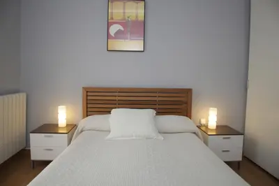 a bedroom with a white bed with two lights on it at Luxury Central Apartment in Barcelona