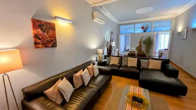 a living room with a leather couch and a table at Luxury Central Apartment in Barcelona