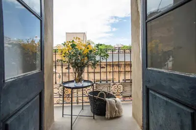 a table with a vase of flowers on a balcony at BBarcelona Sants Flat in Barcelona