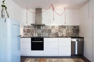 a kitchen with white cabinets and a black and white tiles at Apartment Vila Olímpica Barcelona next to beach & garden in Barcelona